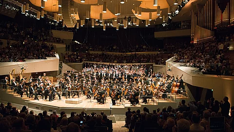 Die Berliner Philharmoniker auf der Bühne der Berliner Philharmonie – das Publikum füllt den Saal bis auf den letzten Platz