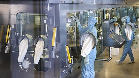 Mitarbeiter im Reinraum bereiten eine Anlage für die sterile Abfüllung des Medikaments Xeomin der Merz Group vor.