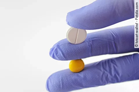 Hand hält zwei verschiedene Tabletten 