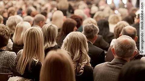 Kongressbesucher hören einem Vortrag zu - Aufnahme von hinten