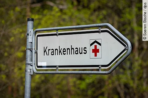 urn:newStraßenschild mit der Aufschrift ‚Krankenhaus‘ und rotem Kreuz, das auf eine Klinik hinweist. sml:dpa.com:20090101:251110-935-944800 Straßenschild mit der Aufschrift ‚Krankenhaus‘ und rotem Kreuz, das auf eine Klinik hinweist.