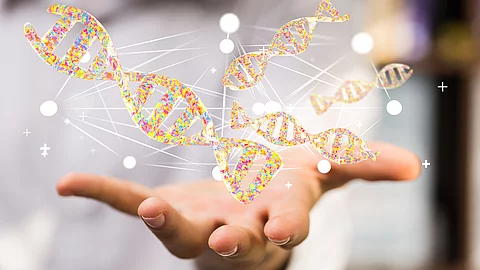 Eine geöffnete Hand, über der mehrere stilisierte, gelb‑orangefarbene DNA‑Doppelhelix‑Grafiken schweben