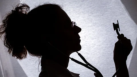 Silhouettenartige Darstellung einer Person im medizinischen Umfeld, die ein Stethoskop hält. Silhouettenartige Darstellung einer Person im medizinischen Umfeld, die ein Stethoskop hält.