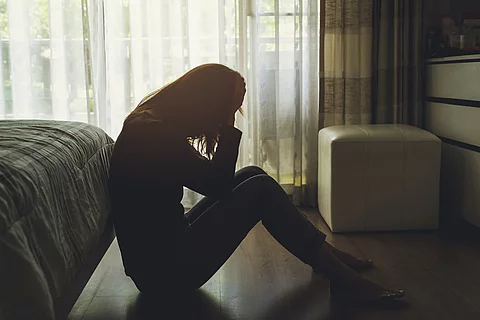 Lonely young woman feeling depressed and stressed sitting head in hands in the dark bedroom, Negative emotion and mental health concept