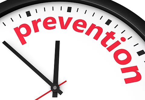 Nahaufnahme einer Uhr, auf deren Zifferblatt das Wort ‚prevention‘ in roten Buchstaben steht Nahaufnahme einer Uhr, auf deren Zifferblatt das Wort ‚prevention‘ in roten Buchstaben steht.