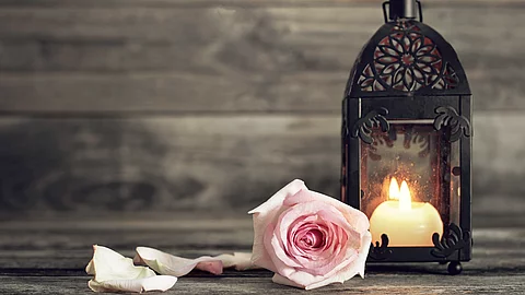 Symbol der Erinnerung: Eine einzelne Rose neben einer brennenden Kerze