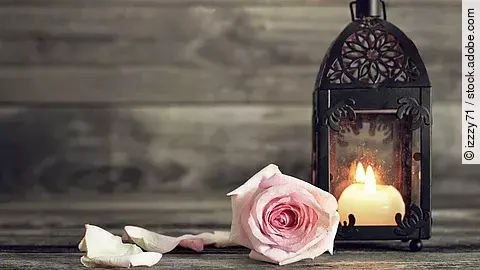 Symbol der Erinnerung: Eine einzelne Rose neben einer brennenden Kerze