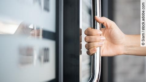 Closeup woman hand holding the door bar to open the door with gl