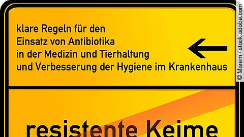 „Gelbes Schild mit schwarzem Rand, darauf der Text: ‚Klare Regeln für den Einsatz von Antibiotika in der Medizin und Tierhaltung und Verbesserung der Hygiene im Krankenhaus‘, darunter durchgestrichen ‚resistente Keime‘.