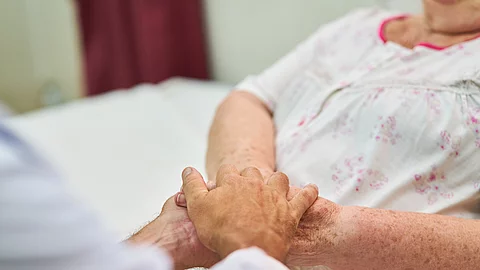 Ein Arzt hält die Hände eines Patienten – eine Geste der Nähe und des Trostes. Die Szene vermittelt Fürsorge und Empathie Ein Arzt hält die Hände eines Patienten – eine Geste der Nähe und des Trostes. Die Szene vermittelt Fürsorge und Empathie