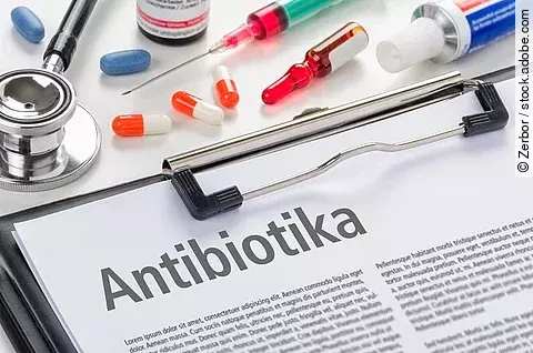 Mehrere Packungen und Blister von Antibiotika liegen nebeneinander, im Vordergrund ist der Schriftzug „Antibiotika“ zu sehen.