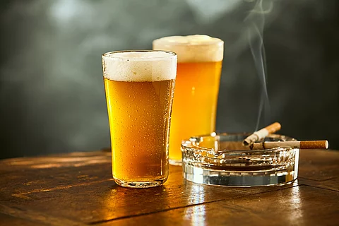 Biergläser und rauchende Zigarette im Aschenbecher
