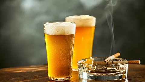 Biergläser und rauchende Zigarette im Aschenbecher