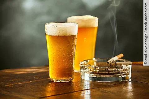 Biergläser und rauchende Zigarette im Aschenbecher