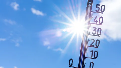 Ein Thermometer zeigt hohe Temperaturen über 40 Grad Celsius vor blauem Himmel mit intensiver Sonneneinstrahlung.