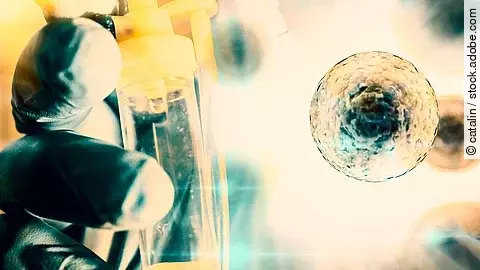 Detailaufnahme eines Laborhandschuhs, der ein Infusionssystem hält, kombiniert mit einer grafisch dargestellten, vergrößerten Zelle