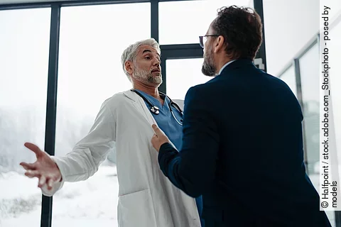 Violence against health workers. Patient is aggressive, have conflict with doctor in hospital corridor. Visitor holding doctor by coat, screaming, threatening him.