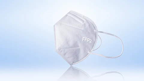 ffp2 Atemschutzmaske Weiße FFP2-Atemschutzmaske liegt vor hellem Hintergrund und ist seitlich dargestellt.