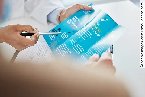 Virus, brochure and hands of doctor in hospital for consulting, medical information or healthcare. Safety, pandemic and advice with patient for disease, protection or covid vaccination in clinic