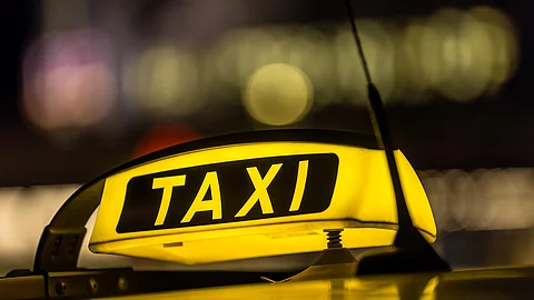 Ein Taxischild leuchtet bei Dunkelheit Ein Taxischild leuchtet bei Dunkelheit