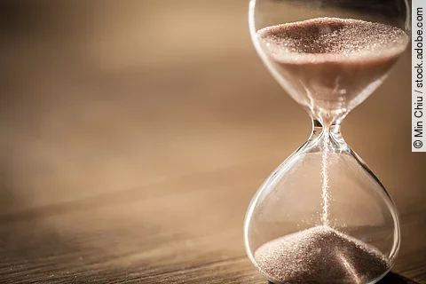 Sand running through the bulbs of an hourglass measuring the pas