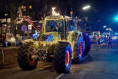 bunt beleuchtete Traktoren fahren in einem Korso nach Lübeck und Hamburg, um krebskranke Kinder zu besuchen.