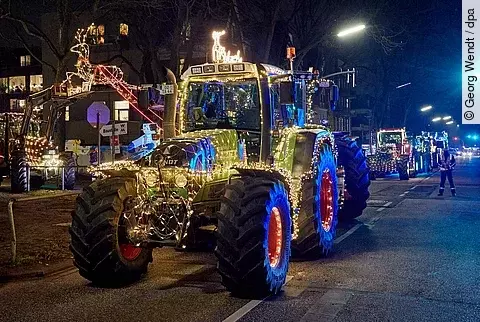 bunt beleuchtete Traktoren fahren in einem Korso nach Lübeck und Hamburg, um krebskranke Kinder zu besuchen.