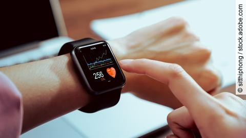 Close up of hand touching smartwatch with health app on the scre