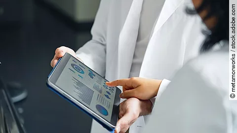 A group of researchers looking at a tablet screen.