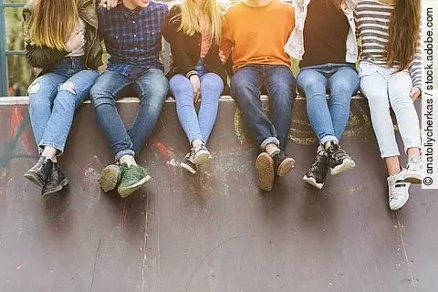 Summer holidays and teenage concept - group of smiling teenagers with skateboard hanging out outside.