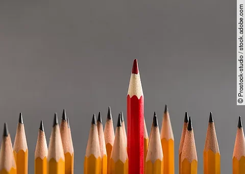 Red pencil sticking out of line with classic ones