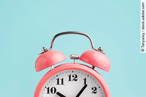 Red alarm clock on blue background