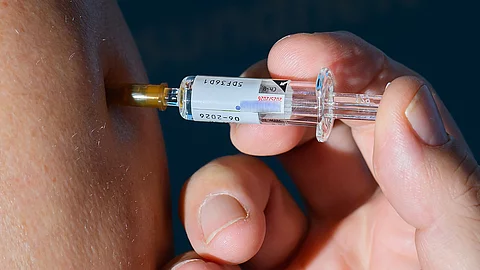 Nahaufnahme einer Hand, die eine Injektion mit einem Grippe-Impfstoff verabreicht Nahaufnahme einer Hand, die eine Injektion mit einem Grippe-Impfstoff verabreicht