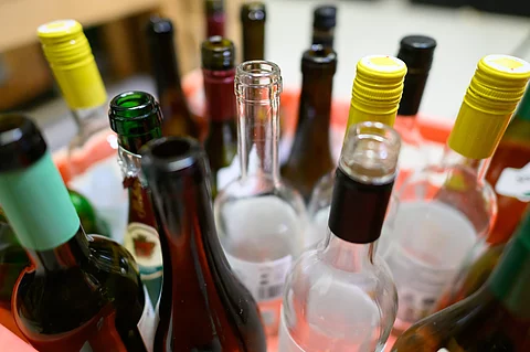 Leere Wein- und Sektflaschen stehen in einer Kiste