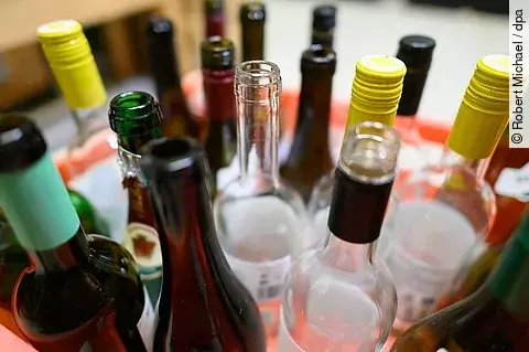 Leere Wein- und Sektflaschen stehen in einer Kiste