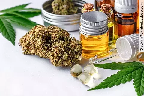 Cannabisblüten, Cannabisöl und Kapseln auf einem Tisch