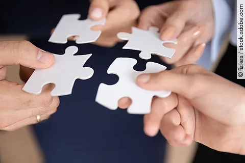 Closeup hands holding white pieces of puzzles find right solutio