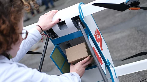 Eine Drohne vom Typ Labfly wird während einer Präsentation mit Transportgut bestückt. Anlass ist eine Versorgungsstudie zum geplanten Einsatz der Fluggeräte zur Patientenversorgung. 