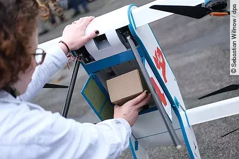 Eine Drohne vom Typ Labfly wird während einer Präsentation mit Transportgut bestückt. Anlass ist eine Versorgungsstudie zum geplanten Einsatz der Fluggeräte zur Patientenversorgung. 