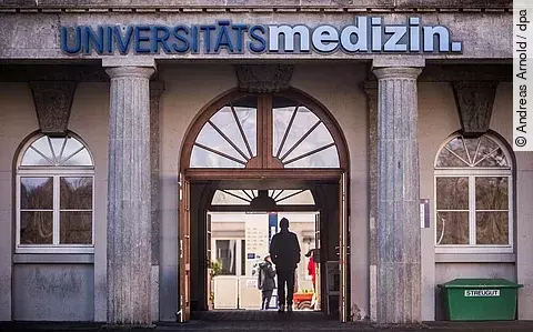 Menschen gehen durch den Zugang zur Universitätsmedizin der Johannes Gutenberg-Universität Mainz