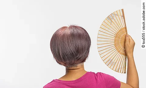 Middle aged woman feel hot flashes or overheated , symptoms of menopause