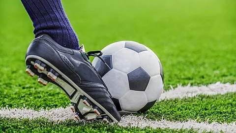 Nahaufnahme eines Fußballschuhs am Ball auf dem Spielfeld