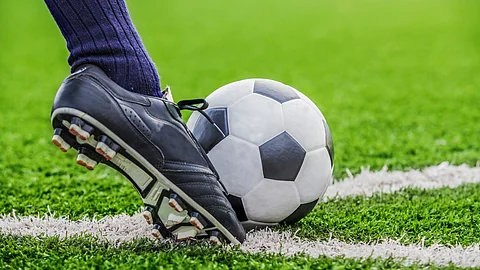 Nahaufnahme eines Fußballschuhs am Ball auf dem Spielfeld