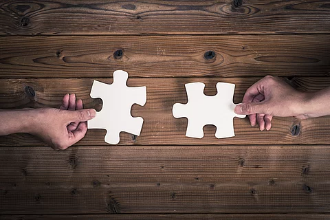 Zwei kompatible Puzzlestücke werden aneinander gehalten