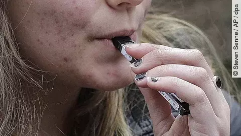 Nahaufnahme einer Hand, die eine E-Zigarette hält