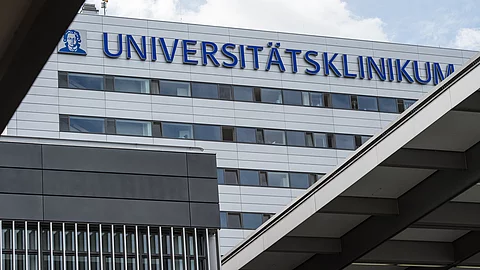 Außenansicht des Universitätsklinikums Frankfurt mit großem Schriftzug „Universitätsklinikum“ an der Fassade.