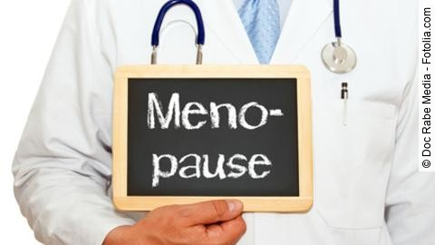 Arzt hält Schild mit Beschriftung "Menopause" hoch