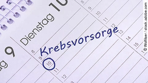 Nahaufnahme eines aufgeschlagenen Kalenders mit handschriftlichem Eintrag ‚Krebsvorsorge‘ am 10. des Monats, blau markiert.
