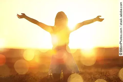 Young woman on field under sunset light