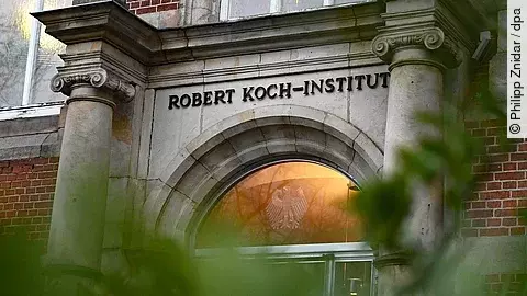 Historische Fassade des Robert Koch-Instituts mit steinernem Portal und Schriftzug „Robert Koch-Institut“ über dem Eingang.
